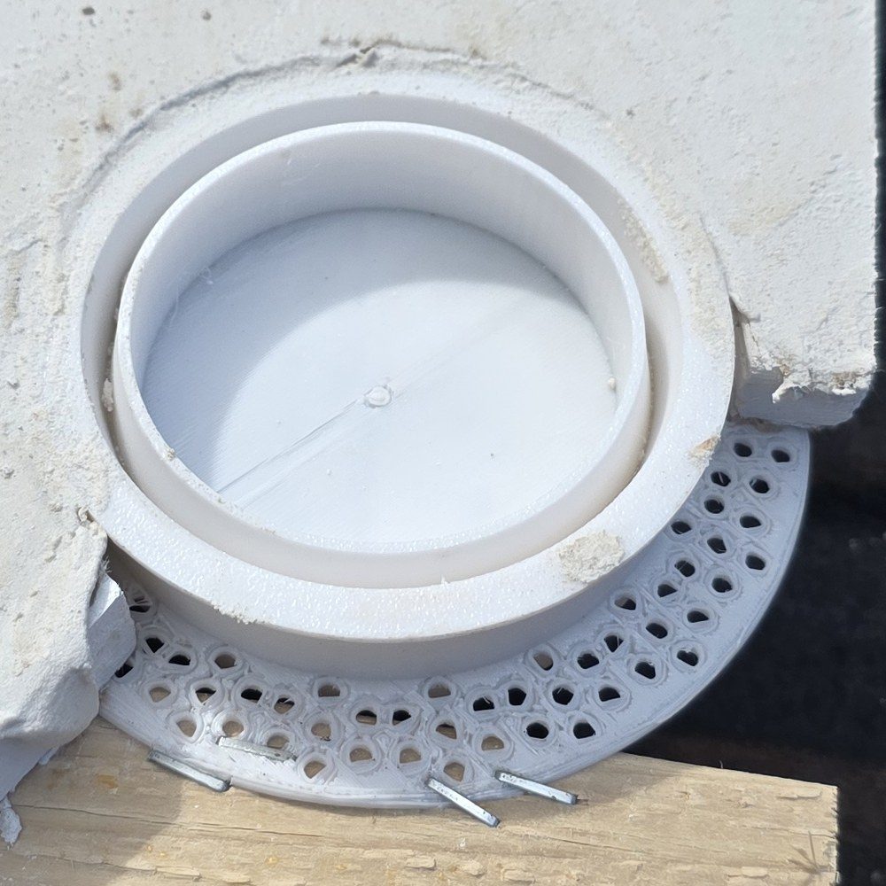 Prototype ring installed in a stucco test panel